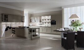 De ruime keuken in beige-grijze tinten biedt zowel een landelijke als jonge en moderne indruk. De kaderfronten met mat grijze lak, de open legmogelijkheden en de klassieke grepen plus een stang waaraan de pannen zijn opgehangen zijn verantwoordelijk voor de landelijke sfeer. 

De keuken bestaat uit een groot keukenblok dat aan de wand is geplaatst. Hier bevindt zich behalve de meeste apparatuur ook de spoelbak met daarboven decoratieve open bergruimte. Een deel van de bovenkasten zijn voorzien van deurtjes met een glazen inzet, waardoor de keuken niet massief werkt. Behalve dit keukenblok aan de wand bestaat de keuken nog uit een ruim kookeiland met fornuis en veel bergruimte in de kastjes daaronder en ook in de bovenkasten die aan de wand zijn opgenomen. Elegantie met mat grijze lak, opgefrist met veel wit en perfect gepland licht - de DOMUS color laat zien, hoe kaderfronten en karakteristieke details voor een aangename sfeer kunnen zorgen. Zuordnung: Stil Landelijke keukens, Planungsart L-vormige keuken