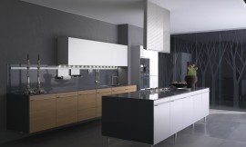Deze keuken, bestaande uit een breed keukenblok met gootsteen en een kookeiland met fornuis, speelt met een contrast tussen houttint en mat wit. De dunne aanrechtbladen en sideboards lopen elegant in elkaar over. Het keukenblok hangt aan de muur en lijkt daarom te zweven; het kookeiland staat op puntige poten en wordt afgemaakt met een bijzondere afzuigkap. Zuordnung: Stil Luxe keukens, Planungsart Keuken met keukeneiland