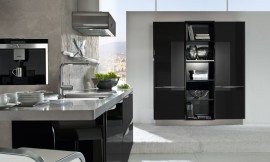 Design eilandkeuken met zwarte hoogglans fronten en metallic tinten. Het aanrechtblad van het keukeneiland loopt direct over in een bartafel. Design afzuigkap met afgeronde hoeken en zwart. Op deze detailfoto ziet u de subtiel afgeronde grepen aan de fronten en de afzuigkap. Zuordnung: Stil Design-keukens, Planungsart Open keuken (woonkeuken)