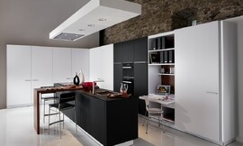 L-keuken met kookeiland en barretje. Klassiek spel met contrast tussen zwart en wit. Een klein uittrekbaar bureau maakt het mogelijk om in de keuken te werken. Zuordnung: Stil Luxe keukens, Planungsart Detail keukenontwerp