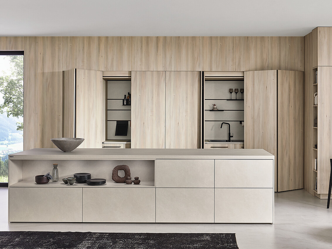 Met een effen en lichte houtafwerking, brengt deze keuken een frisse en verfijnde uitstraling in uw huis. Het L-vormige ontwerp met een eiland biedt praktische ruimte om uw culinaire creativiteit de vrije loop te laten. Zuordnung: Stil Moderne keukens, Planungsart Detail keukenontwerp