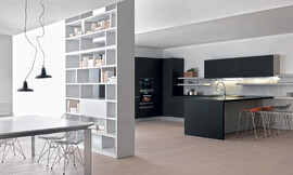 Deze U-vormige keuken is het resultaat van weloverwogen designwerk. Het werkgedeelte is voorzien van een zithoek. De keuken loopt symbiotisch over in het woongedeelte. Zeer sierlijke barkrukken en een eettafel in de eetkamer maken deze reductionistische woonkeuken af. Zuordnung: Stil Design-keukens, Planungsart Keuken met zitgelegenheid