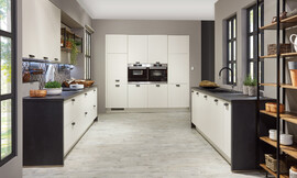 In decente landhuisoptiek presenteert zich deze twee-blokkige keuken. De donkere werkplaat wordt als zijwand verdergezet, wat de keukenblokken een attraktieve inlijsting geeft. Zuordnung: Stil Moderne keukens, Planungsart L-vormige keuken