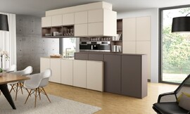 Een bijzondere mate aan wooncomfort wordt bereikt door de kleur- en materiaalkeuze en verlichting. Een warme mokkatint in combinatie met fronten in de kleur 'magnolia' benadrukt de verschillende bereiken van de keuken op speelse wijze. Zuordnung: Stil Design-keukens, Planungsart Keuken met keukeneiland