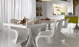 Hier ziet u de Library keuken met in de voorgrond de tafel met twee ronde metallic poten en de elegant gevormde witte stoelen. Zuordnung: Stil Luxe keukens, Planungsart keukenblok