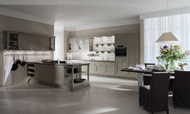 De ruime keuken in beige-grijze tinten biedt zowel een landelijke als jonge en moderne indruk. De kaderfronten met mat grijze lak, de open legmogelijkheden en de klassieke grepen plus een stang waaraan de pannen zijn opgehangen zijn verantwoordelijk voor de landelijke sfeer. 

De keuken bestaat uit een groot keukenblok dat aan de wand is geplaatst. Hier bevindt zich behalve de meeste apparatuur ook de spoelbak met daarboven decoratieve open bergruimte. Een deel van de bovenkasten zijn voorzien van deurtjes met een glazen inzet, waardoor de keuken niet massief werkt. Behalve dit keukenblok aan de wand bestaat de keuken nog uit een ruim kookeiland met fornuis en veel bergruimte in de kastjes daaronder en ook in de bovenkasten die aan de wand zijn opgenomen. Elegantie met mat grijze lak, opgefrist met veel wit en perfect gepland licht - de DOMUS color laat zien, hoe kaderfronten en karakteristieke details voor een aangename sfeer kunnen zorgen. Zuordnung: Stil Moderne keukens, Planungsart Open keuken (woonkeuken)