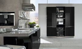 Design eilandkeuken met zwarte hoogglans fronten en metallic tinten. Het aanrechtblad van het keukeneiland loopt direct over in een bartafel. Design afzuigkap met afgeronde hoeken en zwart. Op deze detailfoto ziet u de subtiel afgeronde grepen aan de fronten en de afzuigkap. Zuordnung: Stil Design-keukens, Planungsart Keuken met zitgelegenheid