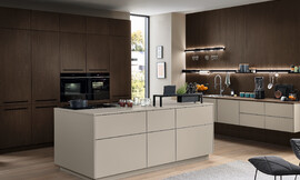 Elegante en functionele keuken met een licht, eenkleurig frontdecor, greeploos design en veelzijdige indeling met eiland en hoogwaardige uitrusting. Zuordnung: Stil Moderne keukens, Planungsart Keuken met zitgelegenheid