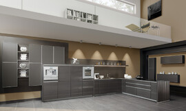 Deze ruime open designkeuken in L-opstelling biedt een kookeiland dat haaks op de wand staat. De grote lades onder het kookeiland zorgen voor genoeg opbergruimte voor alles wat men voor het koken nodig heeft. Tegen de wand is het grotere keukenblok geplaatst. Hier bevinden zich de spoelbak met daarboven een decoratieve legplank. In de vier hoge kasten daarnaast is op praktische werkhoogte de apparatuur opgenomen. De extravagante oppervlakten van de "Structura" ontstaan door het dikke fineer diep te borstelen en aansluitend te lakken met metallic lak. De aluminium greeplijsten zijn optisch terug te vinden in het aluminium kader van de gesatineerde glasfronten. De open vormgeving van deze keuken zorgt voor een warme woonsfeer. Zuordnung: Stil Design-keukens, Planungsart Keuken met zitgelegenheid