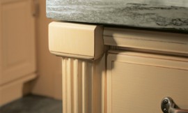 Detailfoto: Pilaster met groeven (zandgeel gelakt) onder aanrechtblad van natuursteen. Zuordnung: Stil Landelijke keukens, Planungsart Keuken met zitgelegenheid