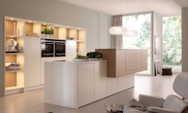 Iedere vorm van symmetrie wordt interessanter, wanneer deze doorbroken wordt. Hier onderbreekt een zijwaarts verschoven kastenblok een verder streng symmetrisch ontwerp. De kastenwand beidt ook open opslagruimte om twee apparaatkasten heen. Zuordnung: Stil Design-keukens, Planungsart Open keuken (woonkeuken)