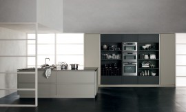 Deze greeploze eilandkeuken neemt niet veel ruimte in beslag en spreekt door zijn interessante kleurencombinatie aan. Verschillende matte grijstinten en een glanzend zwart werkblad. De apparatuurkast rechts heeft veel open opbergruimte voor bijzonder servies of keukenhulpmiddelen die gezien mogen worden. Zuordnung: Stil Design-keukens, Planungsart Keuken met keukeneiland