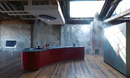 Vrijstaand, licht afgerond keukenblok met design afzuigkap. Mat grijs werkblad en hoogglans bordeauxrode fronten. Greeploze fronten. Zuordnung: Stil Design-keukens, Planungsart Open keuken (woonkeuken)