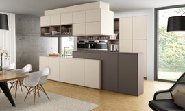 Een bijzondere mate aan wooncomfort wordt bereikt door de kleur- en materiaalkeuze en verlichting. Een warme mokkatint in combinatie met fronten in de kleur 'magnolia' benadrukt de verschillende bereiken van de keuken op speelse wijze. Zuordnung: Stil Landelijke keukens, Planungsart Keuken met keukeneiland