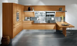 Houten keuken in U-vorm die indruk maakt door een contrast tussen hout en metaal tinten. De houten fronten zijn voorzien van brede, degelijke grepen. Het aanrecht valt op door een gedurfde inzet van roestvrij staal, als werkblad en deels als achterwand. Een simpele maar elegante bar maakt het ontwerp af. Zuordnung: Stil Klassieke keukens, Planungsart Keuken met keukeneiland