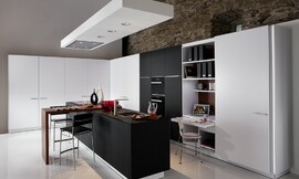 L-keuken met kookeiland en barretje. Klassiek spel met contrast tussen zwart en wit. Een klein uittrekbaar bureau maakt het mogelijk om in de keuken te werken. Zuordnung: Stil Luxe keukens, Planungsart Open keuken (woonkeuken)