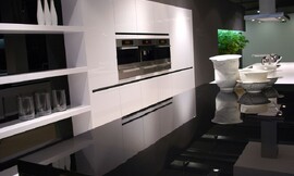 Hier ziet u de unieke combinatie van hoogglans wit en zwart. De kastdeuren hebben greeplijsten. Zuordnung: Stil Design-keukens, Planungsart Keuken met zitgelegenheid