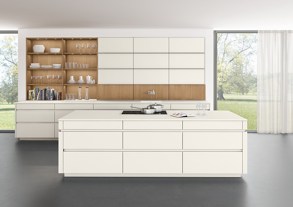 Een witte keuken met greeploze matte lakfronten die er vrijwel niet meer als keuken uitziet, doordat de apparatuur nauwelijks zichtbaar is. Dit maakt deze keuken met een hoog keukenblok aan de wand en een apart kookeiland uitermate geschikt om als open keuken naadloos aan te sluiten op de woonruimte. Ook de afwisseling tussen het tijdloze wit en het koperkleurige eiken uit het programma TIMBER zorgt voor een sfeervol en warm woonaccent. Zuordnung: Stil Design-keukens, Planungsart Keuken met keukeneiland