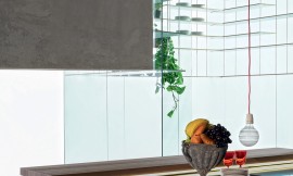 Deze design keuken met bar beschikt over bijzondere eigenschappen zoals een glazen aanrechtblad en een glazen serviesrek boven het kookeiland. Zuordnung: Stil Design-keukens, Planungsart Keuken met zitgelegenheid