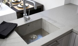 Hier ziet u een gootsteen die van hetzelfde materiaal gemaakt is als het aanrechtblad, en niet boven de rand van het werkblad uitkomt. De gootsteenstop is tegelijk een filter voor grove voedselresten. Zo wordt verstopping voorkomen. Zuordnung: Stil Moderne keukens, Planungsart keukenblok