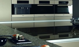 Apparaathoogkast met gember metallic fronten. Design keuken met aanrechtbladen van glas en mozaïek. Koel design met spiegelende hoogglans elementen. Zuordnung: Stil Design-keukens, Planungsart Keuken met zitgelegenheid