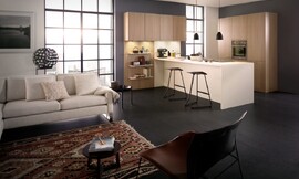 Het kookeiland definieert de overgang tussen woon- en werkbereik. Gelijkkleurige wangen laten het keukeneiland optisch werken als een blok. De kalme houten kasten hebben greeploze fronten. Zuordnung: Stil Moderne keukens, Planungsart U-vormige keuken