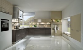Hier ziet u de keuken reflecteren in een glanzende vloer. Eiken houtdecor fronten gecombineerd met beige (rechts). Zitgelegenheid o.a. op kussens tegen het raam. Zuordnung: Stil Moderne keukens, Planungsart L-vormige keuken