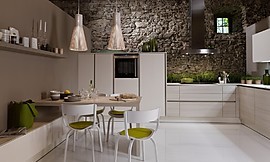Deze lichtvoetige keuken in de L-vorm speelt met een subtiel contrast tussen lichte houttinten en gebroken witte vlakken. Fronten met greeplijsten houden de keuken optisch kalm. Hier ziet u de ingebouwde zitgelegenheid. Zuordnung: Stil Klassieke keukens, Planungsart U-vormige keuken
