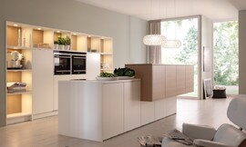 Iedere vorm van symmetrie wordt interessanter, wanneer deze doorbroken wordt. Hier onderbreekt een zijwaarts verschoven kastenblok een verder streng symmetrisch ontwerp. De kastenwand beidt ook open opslagruimte om twee apparaatkasten heen. Zuordnung: Stil Moderne keukens, Planungsart U-vormige keuken