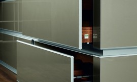 Hoogglans gember metallic fronten met afgeronde boven- en onderkant en houten binnenwerk (notenhout). Zuordnung: Stil Design-keukens, Planungsart Keuken met zitgelegenheid