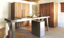 De keukenwerkplaats b2 in opgeruimde, gesloten vorm. Als de kasten dicht zijn is de keuken optisch kalm. Hier zijn de kasten uitgevoerd in mat gelakt hout. Zuordnung: Stil Design-keukens, Planungsart Open keuken (woonkeuken)