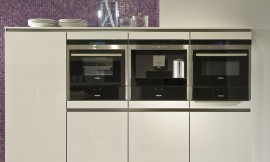Hier ziet u een detail van de hangende hoogkast met drie apparaten en fronten met greeplijsten. Ook het paarse mozaïek is goed zichtbaar. Zuordnung: Stil Moderne keukens, Planungsart U-vormige keuken