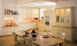 Ruime keuken in landelijke stijl. Crèmekleurige cassette fronten en opzetkast met glazen deurtjes. Keukenachterwand met tegels in verschillende tinten. Schouwen, een houten vloer en andere ornamenten zorgen voor een royale sfeer. Zuordnung: Stil Landelijke keukens, Planungsart Keuken met keukeneiland