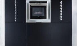 Luxe hoogkast met apparatuurkast. Matzwart met verticaal ornament. In het midden een vak voor inbouwapparatuur zoals de oven. Zuordnung: Stil Luxe keukens, Planungsart Keuken met keukeneiland