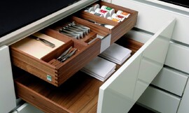 Voorbeeld van een houten bestek- en kruidenlade binnen een grotere lade. Hier uitgevoerd met hoogglans wit front. Deze combinatie biedt perfecte opslagruimte voor besteksets, kruiden en tafellakens. Zuordnung: Stil Moderne keukens, Planungsart keukenblok