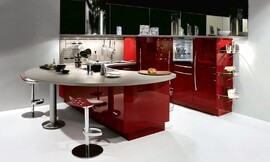 U-keuken met een combinatie van een rond aanrechtblad en bar. Zitgelegenheid op design barkrukken. Open en communicatief keukenconcept. Contrast tussen hoogglans rood en lichtgrijs werkblad. Speels keukenontwerp dat vanuit een hoek gedacht is. Zuordnung: Stil Design-keukens, Planungsart U-vormige keuken