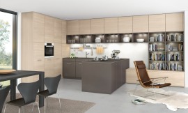Het uitstekende keukenblok en de open kast met led-verlichting drukken een heldere stempel op de ruimte. De keuken loopt optisch in het woonbereik over en leunt daarbij op een lager meubel - ook bruikbaar als zitbank. De greeploze kastenwand met licht houten fronten biedt opslagruimte zonder optisch te domineren. Zuordnung: Stil Moderne keukens, Planungsart L-vormige keuken