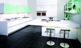 Deze hoogwaardige greeploze keuken met gesatineerd glas werkt koel en rechtlijnig. Het eerste wandelement bestaat uit vier brede onderkasten waarin grote lades zijn opgenomen. Ook de spoelbak bevindt zich in dit keukenelement. Daarboven zijn de twee opvallende brede en exotisch groene hangkasten geplaatst. Deze elegante bovenkast met schuifdeuren "Volare" is in elke breedte en verschillende hoogtes verkrijgbaar. De apparatuur is opgenomen in het volgende keukenelement met hoge kasten. Tot slot is er het ruime kookeiland met zitgelegenheid aan de andere kant en open kasten aan de muur met dezelfde opvallend groene tint als de bovenkasten daar tegenover. Dit open kastsysteem, Varietas, is ook in verschillende formaten verkrijgbaar. Zuordnung: Stil Design-keukens, Planungsart Binneninrichting van de keuken