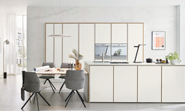 Een greeploze, tijdloze designkeuken met lichtgekleurde fronten. Deze veelzijdige opstelling biedt een zitgelegenheid en een functioneel keukeneiland. Hoogwaardige uitrusting en een praktische apothekerskast maken het compleet. Zuordnung: Stil Moderne keukens, Planungsart Keuken met keukeneiland