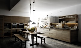 Designkeuken bestaande uit twee keukenblokken met landelijke accenten: houttinten, brede grepen, houten rekken/kasten en in het midden van de keuken een traditionele houten tafel met banken. Op het ene keukenblok, waarin zich ook de spoelbak en het fornuis bevinden, zijn half open kasten geplaatst die ideaal zijn voor het opbergen van het serviesgoed of decoratieve accessoires. Het andere keukenblok bestaat uit hoge kasten die voor een deel open zijn en daardoor aan stellingskasten doen denken. In het midden van de hoge kasten is op praktische werkhoogte de roestvrijstalen apparatuur naast elkaar aangebracht. Zuordnung: Stil Design-keukens, Planungsart Open keuken (woonkeuken)