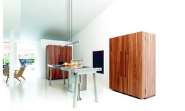 Twee krachtige hoogkasten met donker hout en prachtige tekening sieren deze keukenwerkplaats, die verder nog uit een volledig roestvrijstalen werkbank bestaat. Hier ziet u hoe rustig de keuken werkt wanneer de multifunctionele kasten gesloten zijn. Zuordnung: Stil Design-keukens, Planungsart Keuken met keukeneiland