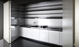 Als de deur gesloten is, kom je niet op het idee, dat er zich daarachter een volwaardige en luxe keuken bevindt. De ideale keuken voor een luxe appartement op een kleine oppervlakte. En toch biedt de keuken alles wat er nodig is. In de deur zelf is handige bergruimte op de drie legplanken. Het keukenblok bestaat uit greeploze witte onderkasten, de spoelbak en het fornuis. Daarboven zijn handige legplanken opgehangen. Zuordnung: Stil Luxe keukens, Planungsart Keuken met keukeneiland