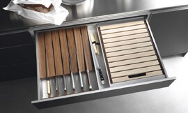 Speciale lade om uw messen beschermd en uit het zicht op te bergen. Hier uitgevoerd in een keukenkastje met metallic tinten en een rvs-aanrechtblad. Zuordnung: Stil Design-keukens, Planungsart U-vormige keuken