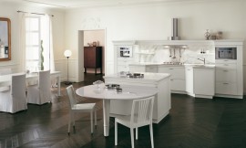 Klassieke, open keuken met zithoek aan kookeiland. Symmetrisch keukenblok met schouw (afzuigkap). Tint: wit in contrast met een prachtige donkere vloer. Links staat ook nog een grotere eetkamertafel. Zuordnung: Stil Klassieke keukens, Planungsart Keuken met keukeneiland