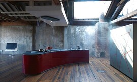 Vrijstaand, licht afgerond keukenblok met design afzuigkap. Mat grijs werkblad en hoogglans bordeauxrode fronten. Greeploze fronten. Zuordnung: Stil Design-keukens, Planungsart Open keuken (woonkeuken)