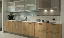 Moderne houten keuken met lichte eiken fronten gecombineerd met dunne witte aanrechtbladen en hangkasten. De deurtjes van de hangkasten zijn voorzien van matglas. Zuordnung: Stil Moderne keukens, Planungsart U-vormige keuken