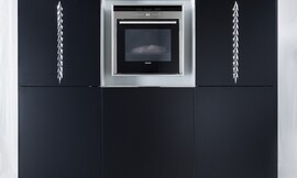 Luxe hoogkast met apparatuurkast. Matzwart met verticaal ornament. In het midden een vak voor inbouwapparatuur zoals de oven. Zuordnung: Stil Luxe keukens, Planungsart Keuken met keukeneiland