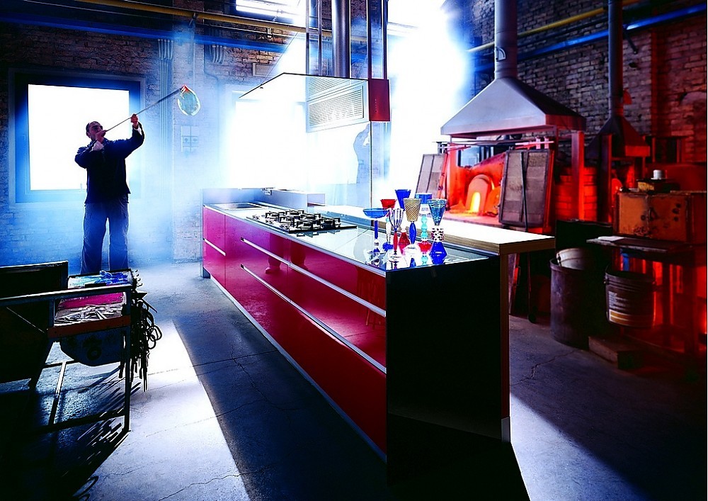 Greeploze design eilandkeuken met design afzuigkap en houten bar. Een glazen plaat verbindt het keukeneiland met de afzuigkap. De houten bar biedt verhoogde zitgelegenheid. Een zeer bijzonder kleurenspel. Zuordnung: Stil Luxe keukens, Planungsart Keuken met keukeneiland